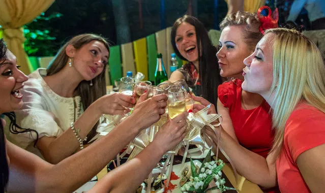 Young women celebrate a birthday at a Donetsk nightspot, on May 23, 2014. Polls show that most young people in Ukraine – a quarter of the population is 24 or younger – do not blur the boundaries between themselves and their powerful neighbor, even if they disagree about how best to relate to Russia, a crucial economic lifeline for many in Ukraine’s industrial east. (Photo by Evelyn Hockstein/The Washington Post)