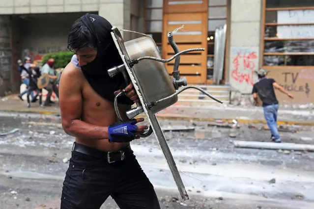 A demonstrator uses a sink as a shield during a protest against Chile's government in Santiago, Chile on November 8, 2019. (Photo by Pablo Sanhueza/Reuters)
