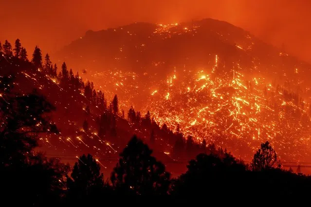 Seen in a long exposure photograph, embers light up hillsides as the Dixie Fire burns near Milford in Lassen County, Calif., on Tuesday, August 17, 2021. (Photo by Noah Berger/AP Photo)