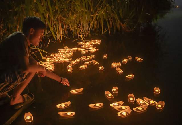 A local resident releases water lanterns to honor ancestors and pray for blessings during the Zhongyuan Festival, the Hungry Ghost Festival, on August 18, 2024 in Qionghai, Hainan Province of China. (Photo by Meng Zhongde/VCG via Getty Images)