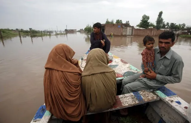 Rescue crews evacuate a family to a safe area in Camp Koruna Akbar in the Pura area of Nowshera District, northwestern Pakistan, August 2, 2015. (Photo by Fayaz Aziz/Reuters)