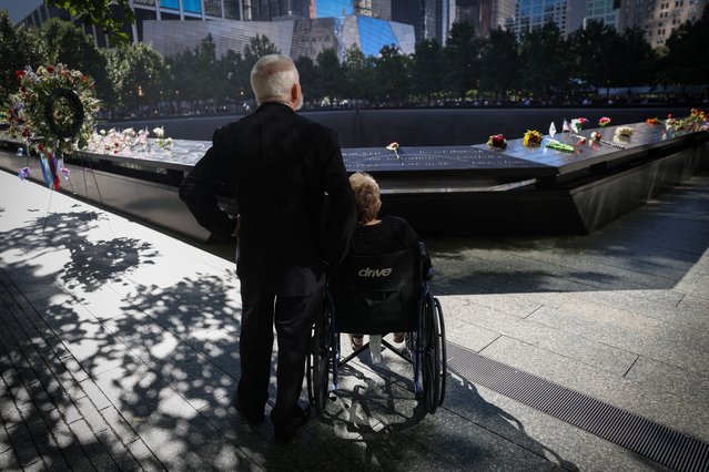 People pause by the north reflecting pool during a ceremony marking the 23rd anniversary of the September 11, 2001 attacks on the World Trade Center at the 9/11 Memorial and Museum in Manhattan, New York City, on September 11, 2024. (Photo by Mike Segar/Reuters)