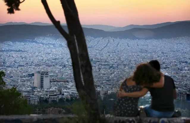 People watch the sun set from Lycabettus Hill  in Athens, Greece, July 7, 2015. (Photo by Cathal McNaughton/Reuters)
