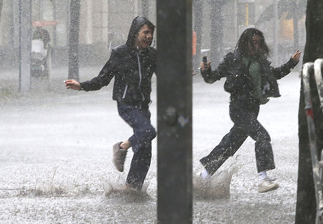 People run for shelter during heavy rainfalls in Berlin, Germany, Thursday, June 29, 2017.  Weather forecasts predict changeable weather for Germany the next days. (Photo by Wolfgang Kumm/DPA via AP Photo)