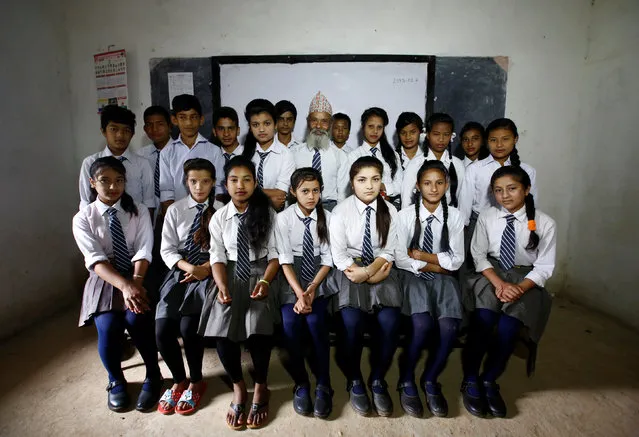 Durga Kami (C), 68, and his classmates pose for a group picture in their classroom at Shree Kala Bhairab Higher Secondary School in Syangja, Nepal, June 5, 2016. (Photo by Navesh Chitrakar/Reuters)