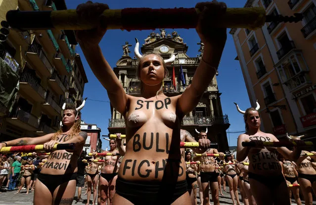 Animal rights protesters stand still before breaking mock banderillas containing red powder, which covered them during a demonstration for the abolition of bull runs and bullfights a day before the start of the famous running of the bulls San Fermin festival in Pamplona, northern Spain, July 5, 2017. (Photo by Eloy Alonso/Reuters)