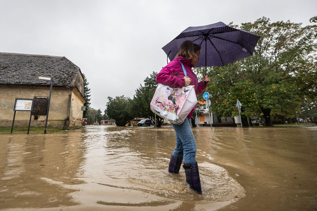 A resident walks in a flooded street in the town of Stupava, situated a few kilometers west of Bratislava, Slovakia, on September 15, 2024. (Photo by Tomáš Benedikovič/AFP Photo)