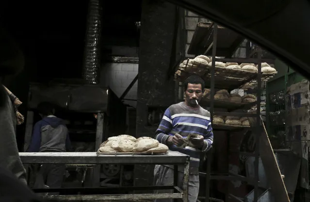 In this Tuesday, February 14, 2017 photo, a vendor counts his money at a bread stand in the Sayeda Zeinab neighborhood of Cairo, Egypt. Egyptians are cutting spending and trying to make it through the country’s worst inflation in a decade under President Abdel-Fattah el-Sissi’s economic reforms. With inflation now nearing 30 percent – and little public space for discontent – they’re finding they can do little else but bear down and hope the promised benefits of reform eventually come. (Photo by Nariman El-Mofty/AP Photo)