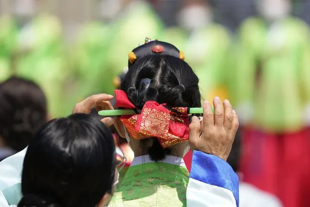A women makes an adjustment to a young woman's hair during a ceremony to reenact the 50th Coming of Age Day at Namsangol Hanok Village in Seoul, South Korea, Monday, May 16, 2022. The ceremony was held for young men and women who'll be 20 years old this year. (Photo by Lee Jin-man/AP Photo)