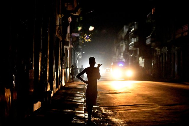 People stand in the street at night as Cuba is hit by an island-wide blackout, in Havana, Cuba, on October 18, 2024. (Photo by Norlys Perez/Reuters)