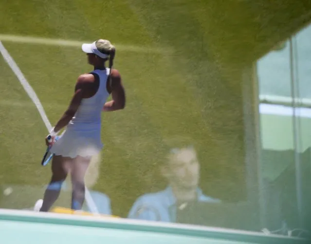 A player is seen through the reflection of a commentry box Wimbledon Tennis Championships in London, June 30, 2015. (Photo by Stefan Wermuth/Reuters)