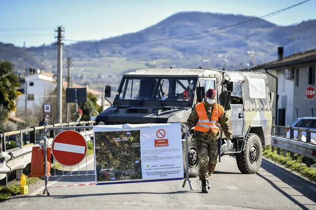 An Italian army soldier blocks off a road leading to the village of Vo'Euganeo, in Italy's northern Veneto region, on Friday, February 28, 2020. Vo'Euganeo is the epicenter of the Veneto cluster of the new virus. (Photo by Claudio Fulan/LaPresse via AP Photo)