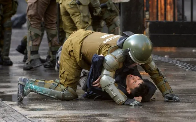 Chilean riot police arrest a student during protests against the government of Sebastian Piñera on its second anniversary on March 11, 2020 in Santiago, Chile. Massive protests and social unrest started on October 2019 due to a raise in the subway fare which triggered more demands related to inequality. (Photo by Claudio Santana/Getty Images)