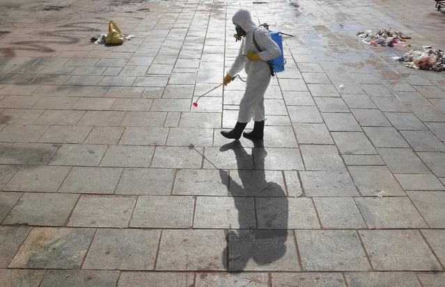 A member of India's national disaster response force sprays disinfectants as a precautionary measure against COVID-19 at the Charminar monument in Hyderabad, India, Sunday, March 22, 2020. (Photo by Mahesh Kumar A./AP Photo)