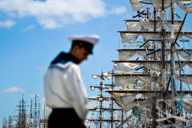 A sailor stands in front of several ships moored at Santa Apolonia dock in Lisbon, July 22, 2016, during the Tall Ships' Races 2016. The international event which brings together sail training Tall Ships for a friendly competition. (Photo by Patricia de Melo Moreira/AFP Photo)