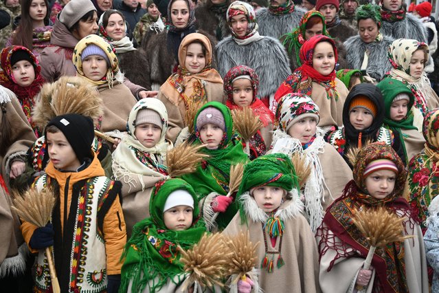 Children wearing traditional clothes carry “didukh” as they take part in a Christmas Eve procession in Lviv on December 24, 2024, amid the Russian invasion of Ukraine. 'Didukh' is a Ukrainian Christmas decoration made of bunches of wheat, symbolising sacrifice and literally meaning “spirit of grandfather”. (Photo by Yuriy Dyachyshyn/AFP Photo)