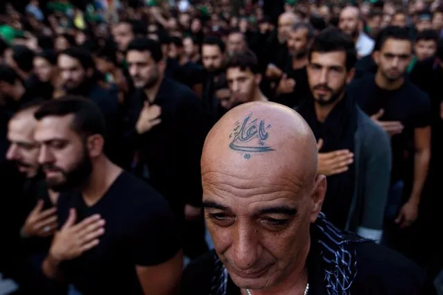 In this Saturday, Oct. 24, 2015 photo, a Lebanese Shiite supporter of Hezbollah with a tattoo on his head that reads in Arabic, “Oh Ali”, beats his chest during the holy day of Ashoura, in the southern suburb of Beirut, Lebanon. A growing number of Shiite Muslims in Lebanon are getting tattoos with religious and other Shiite symbols since the civil war in neighboring Syria broke out five years ago, fanning sectarian flames across the region. (Photo by Hassan Ammar/AP Photo)