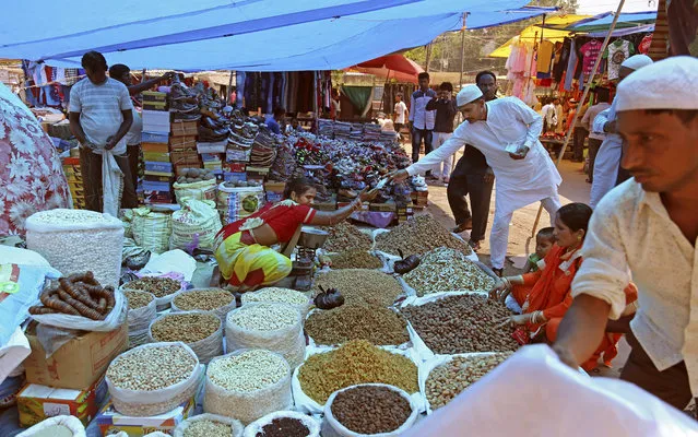 In this June 16, 2017, file photo, Indians buy dry fruits from a roadside vendor at a market in New Delhi, India. Three years later Prime Minister Narendra Modi came to power, India's economic prospects are looking decidedly more grim. India's economic expansion has slowed to its lowest level in three years. Small businesses are struggling, or even shutting down, after a major overhaul to both the country's currency and sales tax system. (Photo by Altaf Qadri/AP Photo)