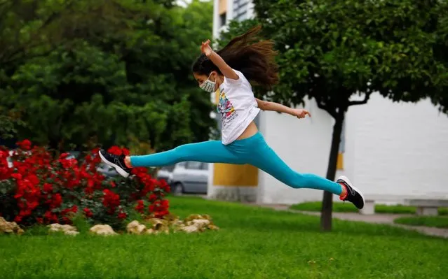 A girl wearing a face masks jumps at a street in Cordoba, Spain, 26 April 2020, on the first day that minors have been allowed for an hour a day outside of their homes following a nationwide lockdown ordered 44 days ago in Spain in an attempt to figth the spread of the coronavirus disease (COVID-19) pandemic. (Photo by SALAS/EPA/EFE/Rex Features/Shutterstock)