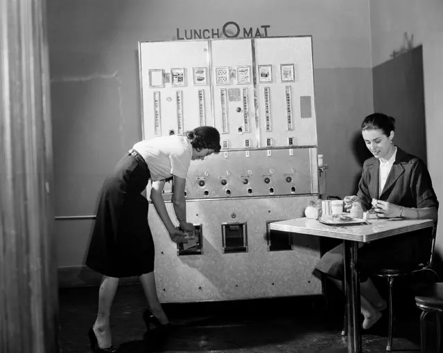 An automatic lunch vending machine, which carries hot and cold foods, is demonstrated, September 10, 1952 in New York by Jo Vanna, who is taking a sandwich from a slot. Gloria Loranz is at the table. The new machine, called the Lunch-O-Mat, vends hot and cold sandwiches, pies and pastries, milk, chocolate milk, juices and hot coffee. There are seven food-holding divisions, all interchangeable except that for coffee, allowing for concentration on the most popular foods in any location. (Photo by AP Photo)