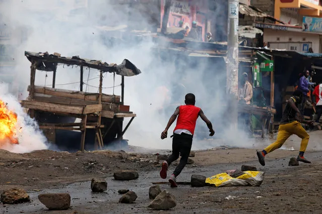 Protesters supporting opposition leader Raila Odinga, run away from police in the slum area of Mathare in the capital Nairobi, Kenya on October 26, 2017. (Photo by Siegfried Modola/Reuters)