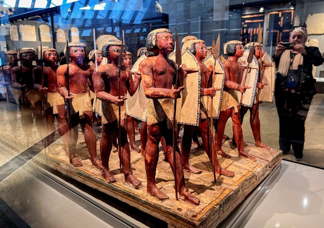 A visitor takes a photo of Pharaonic statues displayed at the Grand Staircase of the Grand Egyptian Museum during a partial trial in Giza, Egypt, on October 15, 2024. (Photo by Mohamed Abd El Ghany/Reuters)