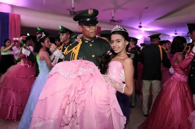 A cancer patient dances with a cadet from Nicaragua's Military Academy during her “Quinceanera” (15th birthday) party at a hotel in Managua September 20, 2014. A quinceanera is a traditional celebration for a girl turning 15. The Nicaragua's Association of Mother and Father of Children with Leukemia and Cancer (MAPANICA) organizes quinceaneras for cancer patients annually, and there were 44 celebrants in 2014. (Photo by Oswaldo Rivas/Reuters)