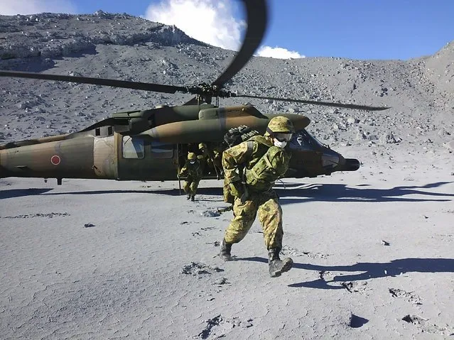 Japan Self-Defense Force (JSDF) soldiers run after landing in a helicopter for a rescue operation near the peak of Mt. Ontake, which straddles Nagano and Gifu prefectures, central Japan, in this handout photograph released by Joint Staff of the Defence Ministry of Japan and taken September 29, 2014. (Photo by Reuters/Joint Staff of the Defence Ministry of Japan)