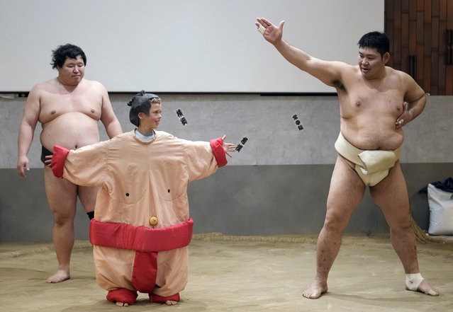 Wearing a sumo wrestler costume, Fletcher (C), an 8-year-old tourist from Australia, practices with former sumo wrestler Jokoryu (R) on a sumo ring before tourists from abroad during a lunch sumo show at the restaurant Yokozuna Tonkatsu Dosukoi Tanaka in Tokyo, Japan, 10 January 2024. The Yokozuna Tonkatsu Dosukoi Tanaka, a restaurant in Tokyo managed by retired sumo wrestlers is becoming a popular spot for tourists because of its performances in English, that allows the foreign public to expand its knowledge about the iconic Japanese sport while giving a new work life to retired professionals. (Photo by Franck Robichon/EPA)