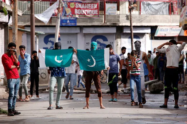 Protesters hold the flag of Pakistan during a protest in Srinagar against the recent killings in Kashmir, August 26, 2016. (Photo by Danish Ismail/Reuters)