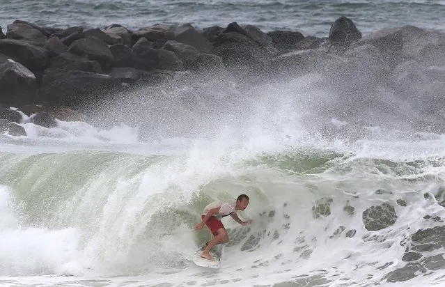 A surfer gets into the tube while surfing the swell from Tropical Storm Hermine at St. Andrews State Park in Panama City Beach, Fla., on Thursday, September 1, 2016. Residents and businesses along Florida’s Gulf coast put up shutters, nailed plywood across storefronts and braced Thursday for Tropical Storm Hermine, a system the governor called potentially “life-threatening” likely to become the first hurricane to strike the state in over a decade. (Photo by Andrew Wardlow/The News Herald via AP Photo)