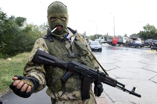 A Pro-Russian separatist fighter holds a grenade as he stands guard at a check point on September 10, 2014 on a road of the Donetsk airport. Ukrainian President Petro Poroshenko said on Wednesday that most Russian troops had been withdrawn from the country, in a move he said boosted the prospects for peace. (Photo by Philippe Desmazes/AFP Photo)