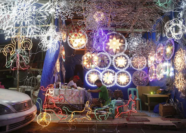 In this December 9, 2017, photo, lantern makers work on traditional Christmas lanterns locally known as “parols” in a side street shop in Manila, Philippines. These small lanterns traditionally decorate many Filipino homes during the Christmas holidays. (Photo by Iya Forbes/AP Photo)