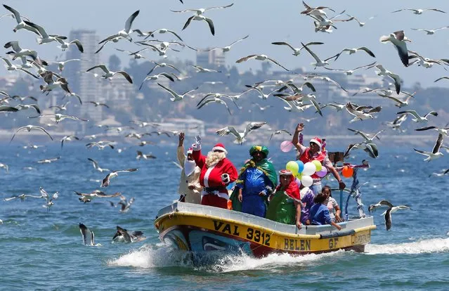 A man dressed in a Santa Claus outfit waves to people from a fisherman’s boat on Christmas Eve along the coast of Valparaiso, Chile on December 24, 2017. (Photo by Rodrigo Garrido/Reuters)