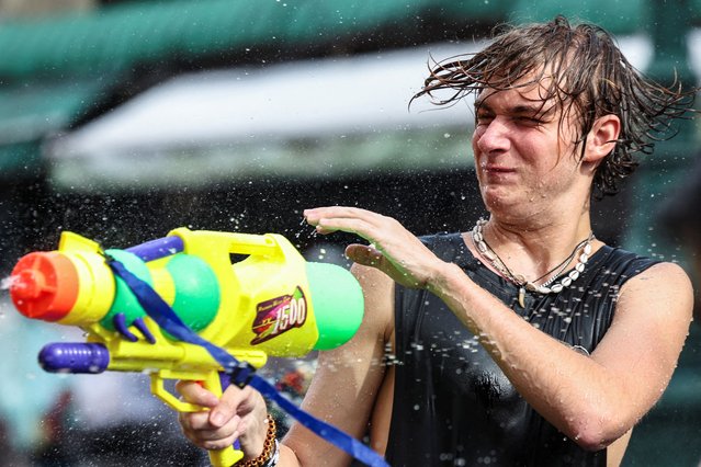 A reveller plays with a water gun as he celebrates the Songkran holiday, which marks the Thai New Year, in Bangkok, Thailand, on April 12, 2025. (Photo by Chalinee Thirasupa/Reuters)