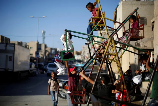 Palestinian children play on a mini ferris wheel, during the first day of the Muslim holiday Eid al-Adha at Al-Baqaa Palestinian refugee camp, near Amman, Jordan September 12, 2016. (Photo by Muhammad Hamed/Reuters)