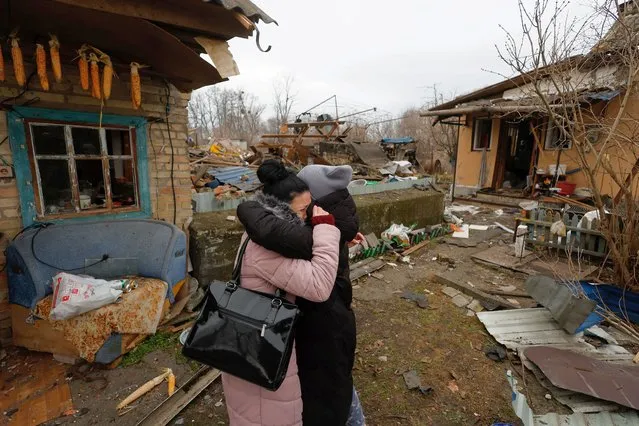 A local resident Yana embraces a friend as she reacts next to her mother's house damaged during a Russian missile strike, amid Russia's attack on Ukraine, in Kyiv, Ukraine on December 29, 2022. (Photo by Valentyn Ogirenko/Reuters)