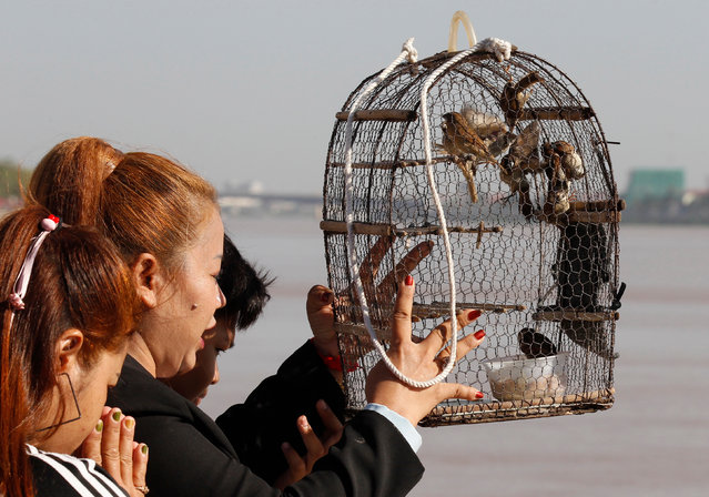 Cambodian woman releases birds at a park in front of the Royal Palace in Phnom Penh, Cambodia, 26 August 2020. According to local? media reports, the number of foreign tourists visiting Cambodia has dropped sharply due to the COVID-19 pandemic. Tourism is a main sector supporting Cambodia's economy. (Photo by Mak Remissa/EPA/EFE)