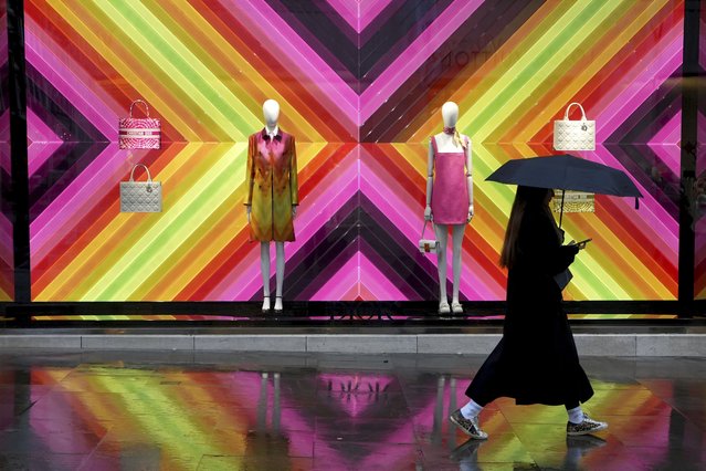 A pedestrian walks past a shop in New Bond Street as it rains in London, Friday, February 7, 2025. (Photo by Kirsty Wigglesworth/AP Photo)