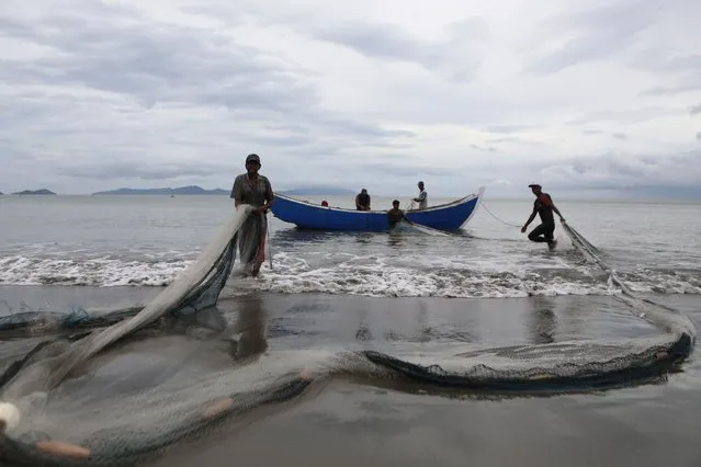 Fishermen pull their nets near a beach in Banda Aceh, Indonesia, 24 January 2023. The Meteorological, Climatological, and Geophysical Agency (BMKG) issued an extreme weather warning between 23-35 January for the Aceh region, including an alert for big waves on the coast as well as at sea. (Photo by Hotli Simanjuntak/EPA/EFE/Rex Features/Shutterstock)