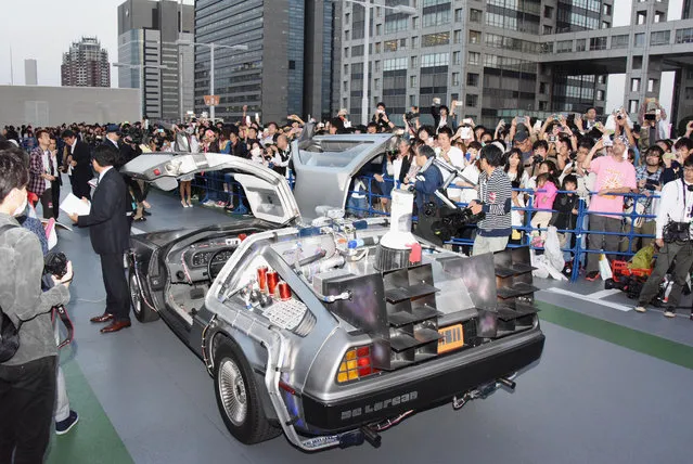 DeLorean, remodeled similar to the "Back to the Future Part II" time machine, that runs on bioethanol fuel made from old clothes, is shown to fans during a special celebration event organized by NBC Universal Entertainment Japan to mark the 30th anniversary of the sci-fi film's debut, in Tokyo Wednesday, October 21, 2015. (Photo by Ayaka Aizawa/Kyodo News via AP Photo)
