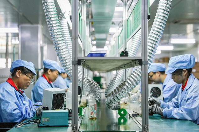 Employees work on a production line of electric car charging station at a factory in Ruichang, in central China's Jiangxi province on July 9, 2025. (Photo by AFP Photo/China Stringer Network)