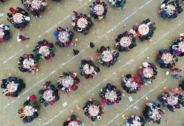 Aerial view of villagers eat and enjoy an art performance together at Anzhou District on February 11, 2018 in Mianyang, Sichuan Province of China. “Two thousand people feast” is held for villagers from 17 village groups to strengthen community bonds and celebrate new year. (Photo by VCG/VCG via Getty Images)