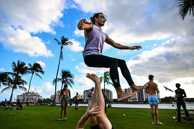People perform acroyoga style exercices at South Pointe in Miami Beach, Florida, on February 8, 2023. (Photo by Chandan Khanna/AFP Photo)