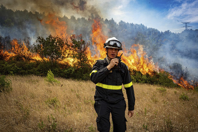 This photo, provided by the Securite Civile on Thursday August 7, 2025, shows a rescuer from the Securite Civile next the wildfire near Saint-Laurent-de-la-Cabrerisse, southern France, Wednesday, Aug. 6, 2025. (Photo by Securite Civile via AP Photo)