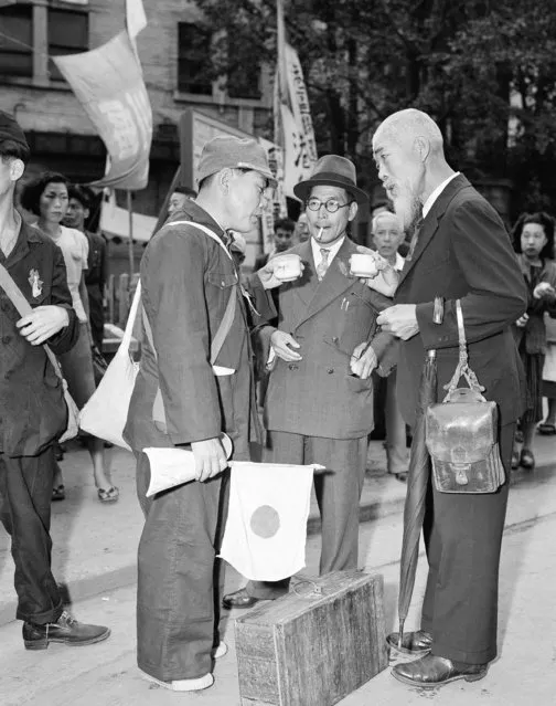 In this October 7, 1949, file photo, relatives meet one of the Japanese repatriates from Manchuria and have cups of hot tea supplied by the Japanese Red Cross at the Tokyo station in Tokyo. The bombs stopped falling 75 years ago, but it is entirely possible – crucial even, some argue – to view the region’s world-beating economies, its massive cultural and political reach and its bitter trade, territory and history disputes all through a single prism: Japan’s aggression in the Pacific during World War II. (Photo by AP Photo/File)