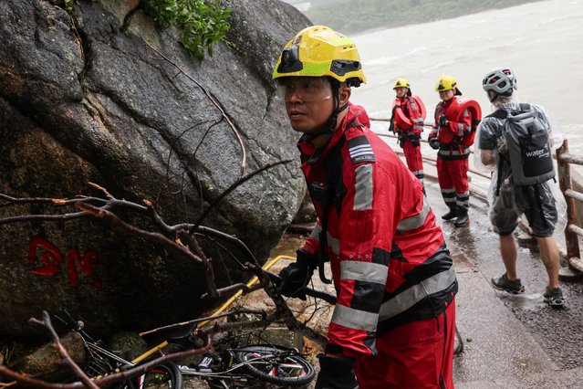A firefighter moves a fallen branch after Super Typhoon Ragasa passes, as he assesses damage from storm surge and flooding, in Hong Kong, China, on September 24, 2025. (Photo by Tyrone Siu/Reuters)