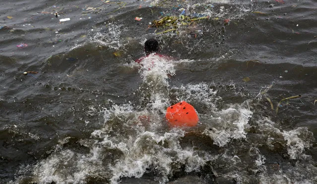 A man uses makeshift fins as he swims into the waters off the Manila Bay to collect recyclable materials, after Typhoon Sarika slammed central and northern Philippines, October 16, 2016. (Photo by Erik De Castro/Reuters)