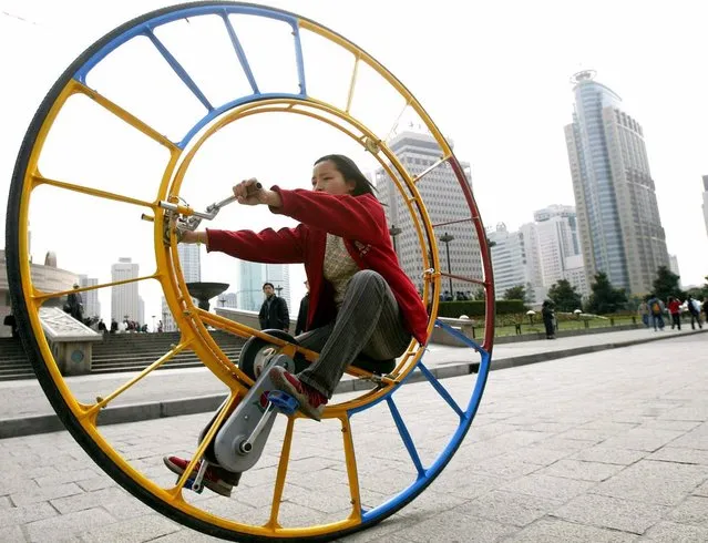 A woman rides an unicycle at a park in Shanghai February 28, 2004. The unicycle was designed by Chinese inventor Li Yongli who called it “the number one vehicle in the world”. (Photo by Reuters/China Photos)