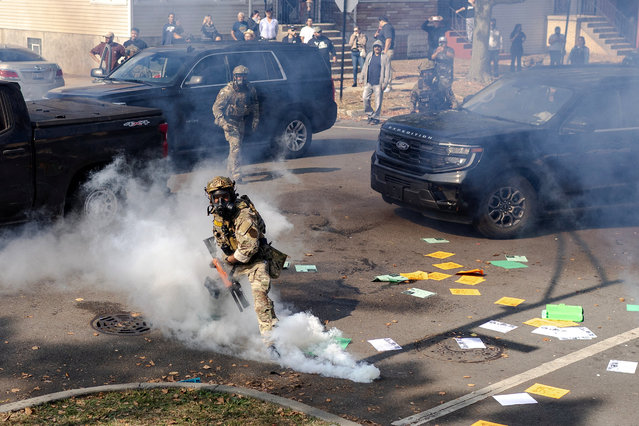 A federal agent prepares to throw a tear gas canister at community members during clashes on Chicago’s South Side, on October 14, 2025. Federal agents fired tear gas at a crowd during a standoff on Chicago's South Side after a vehicle was damaged during a chase to detain a man, according to Chicago police, who responded to the incident. (Photo by Jim Vondruska/Reuters)